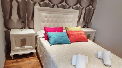 a bedroom with a bed with colorful pillows on it at vivienda rural AZALEA in Cortijos Nuevos