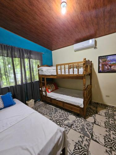 a room with two bunk beds and a window at El Rancho De Don Moncho Hostel 