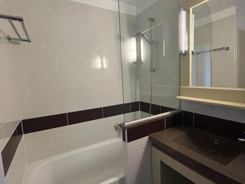 une salle de bain avec baignoire et douche en verre dans l'établissement Cap Esterel: Duplex 3P, Terrasse, Solarium, Piscine Accès, 6 pers - FR-1-504-668, à Saint-Raphaël