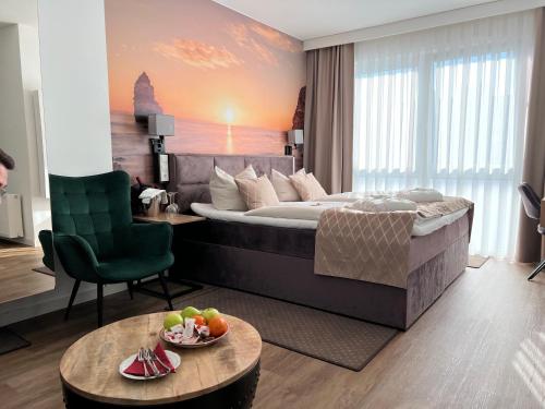 ヴェスターシュテーデにあるHotel Ammerländer Hofのベッド、椅子、テーブルが備わるホテルルームです。