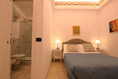 巴里的住宿－L.T. BARI SUITE _ Locazioni Turistiche _，一间卧室设有一张床、淋浴和卫生间