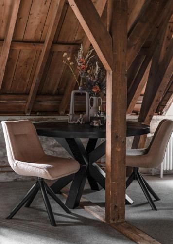 a table with two chairs and a vase on it at B&B Slapen bij DKW in Oldebroek