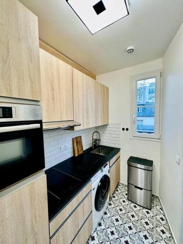 Il comprend une cuisine équipée d'un lave-linge, d'un évier et d'un lave-vaisselle. dans l'établissement Studio « lescostreet » Les Halles : vue Tour Eiffel, à Paris