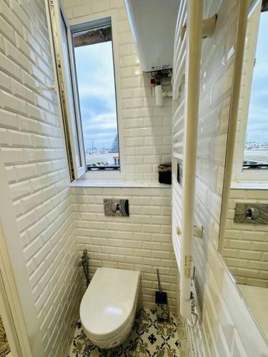 Elle comprend une petite salle de bains pourvue de toilettes et d'une fenêtre. dans l'établissement Studio « lescostreet » Les Halles : vue Tour Eiffel, à Paris