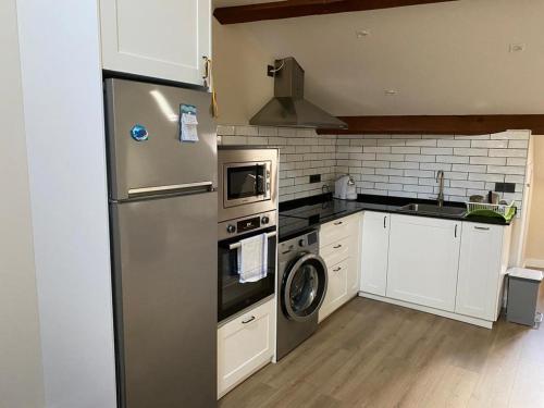 a kitchen with a stainless steel refrigerator and a dishwasher at La Casa de Loli in Luarca
