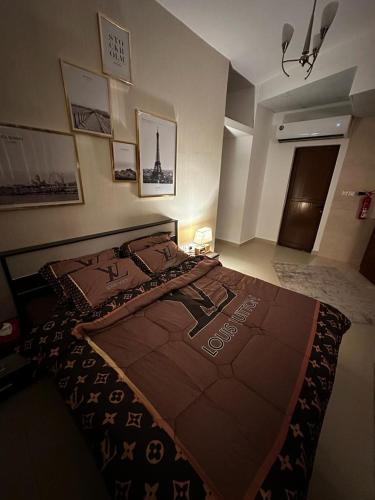 ein Schlafzimmer mit einem großen Bett mit einer braunen Decke in der Unterkunft Studio FLAT in Ajman in Ajman 