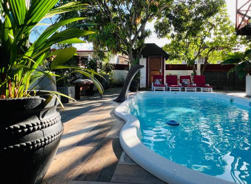 a swimming pool in a yard with plants at Villa Famiri Boutique hotel in Paramaribo