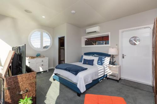 a bedroom with a blue bed and a tv at New Floating Luxury: Unique Houseboat Retreat in Fleming Island