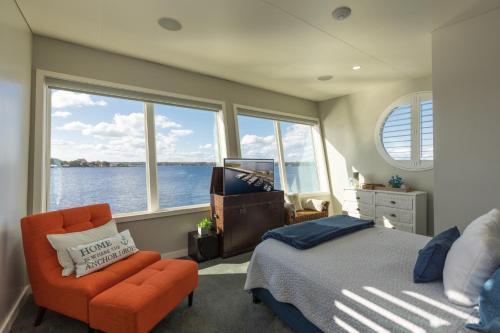 a bedroom with a bed and a chair and a window at New Floating Luxury: Unique Houseboat Retreat in Fleming Island
