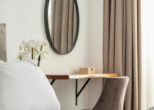 a bedroom with a mirror and a table and a bed at G Mare Boutique Hotel in Neos Marmaras