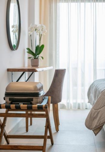 a pile of luggage sitting on a chair in a bedroom at G Mare Boutique Hotel in Neos Marmaras