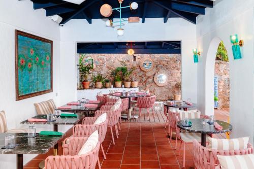The Pink Palm Hotel - Adults Only في شارلوت أملي: مطعم بطاولات وكراسي وجدار من الطوب