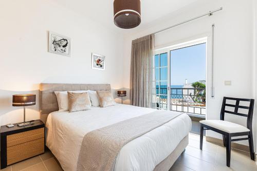 um quarto com uma cama grande e uma janela grande em Rossio Sea View By ALzira em Albufeira