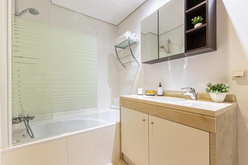 La salle de bains est pourvue d'un lavabo, d'une baignoire et d'une douche. dans l'établissement Rossio Sea View By ALzira, à Albufeira