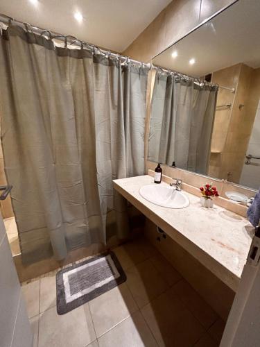 a bathroom with a sink and a shower with a mirror at DEPTO EN AV ROCA PARA HASTA 4 PERSONAS - Edificio MIRÓ2 in Santiago del Estero