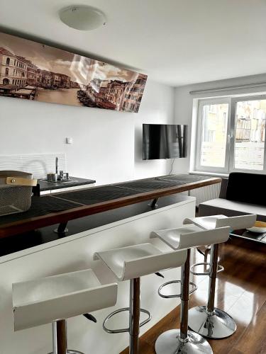 - une cuisine avec un comptoir et des tabourets dans une pièce dans l'établissement Apartament Pod Kamienną Górą XII, à Gdynia