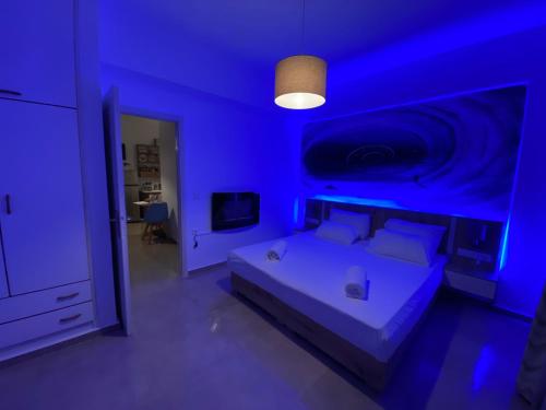 um quarto azul com uma cama e uma televisão em XdreamPort em Hersonissos