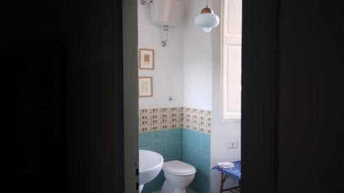 La salle de bains est pourvue de toilettes blanches et d'un lavabo. dans l'établissement pietrolafontaine19, à Viterbe