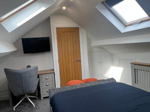 een slaapkamer met een bed, een stoel en dakramen bij Tredegar property, unique location with luxury bedroom, bathroom & dining room in Sirhowy