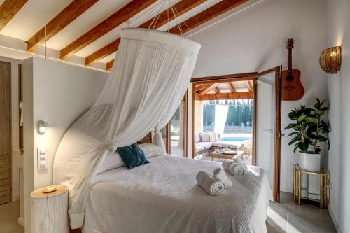 1 dormitorio con 1 cama blanca con dosel en Villa Can Figuera en Alcúdia