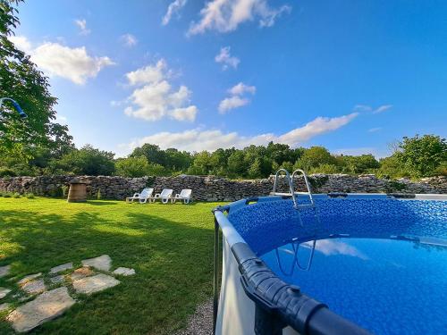 una piscina en un patio con una pared de piedra en House Mlun, en Buzet