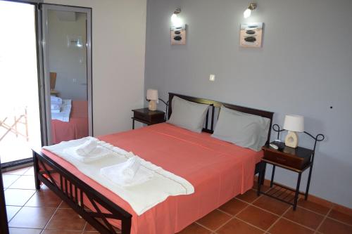 a bedroom with a bed with a red comforter at Agyra Studios in Vasilika