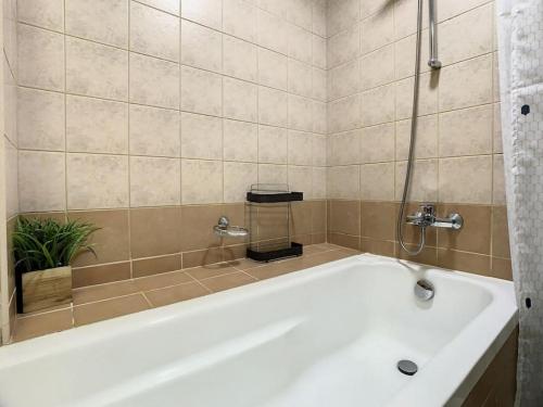 baño con bañera blanca y planta en Key View - Time place en Dubái