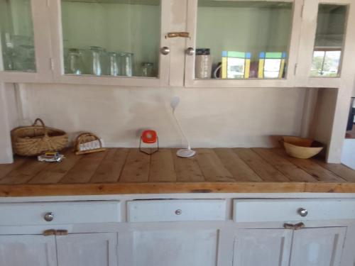 a kitchen with white cabinets and a wooden counter top at AGAVE HOUSE in Prince Albert