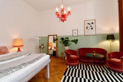 維也納的住宿－Romantic Urban Living，一间卧室配有一张床、椅子和吊灯