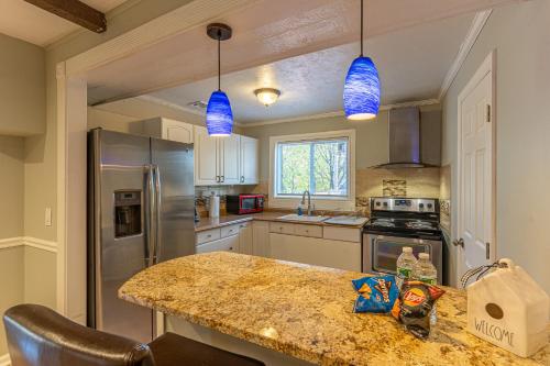 a kitchen with a granite counter top with blue pendant lights at H2 1 Bedroom Downtown Stamford in Stamford