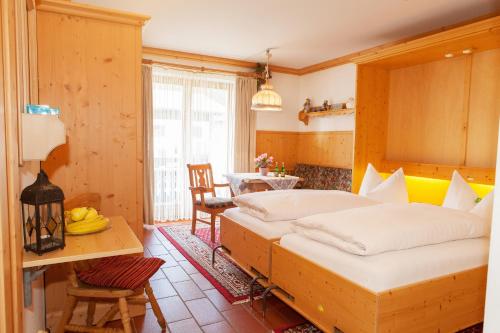 a bedroom with two beds and a table and a dining room at Frühlingshof in Reit im Winkl