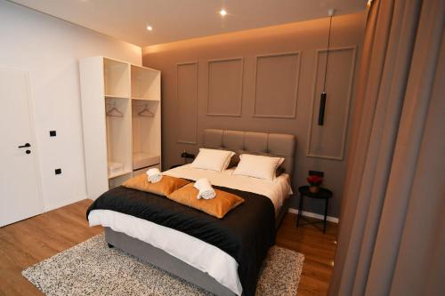 a bedroom with a large bed with two towels at Nicole Apartment in Rijeka