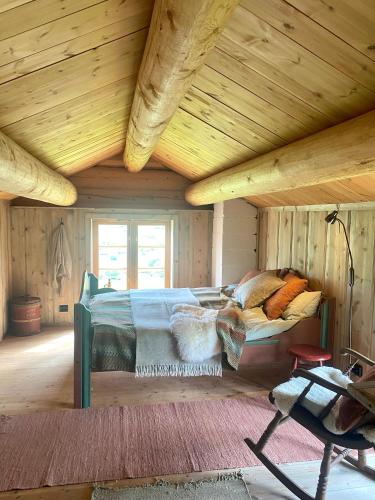 een slaapkamer met een bed in een houten plafond bij Kufjøset in Skjåk