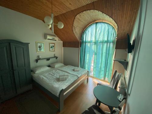 a bedroom with a bed and a large window at Fiorita Vendégház in Eger