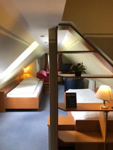 Zimmer mit 2 Etagenbetten und einem Schreibtisch in der Unterkunft Garni Hotel-Pension Holum in Neuharlingersiel