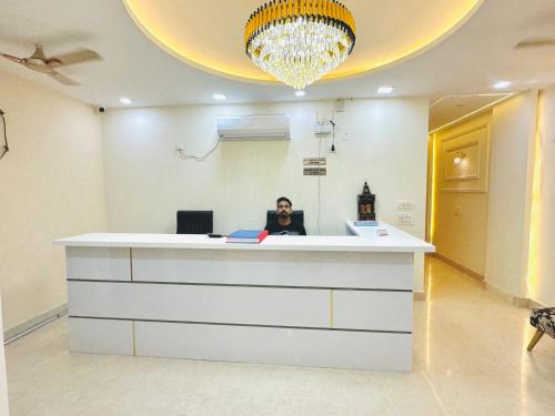 una mujer sentada en una recepción en una habitación en Frankstay By Hotel SAMRAT RESIDENCY 10 Mints Walking Distance Nizamuddin Railway Station en Nueva Delhi