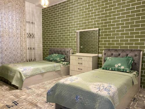 1 dormitorio con 2 camas y espejo en Duplex 80A, en Tashkent