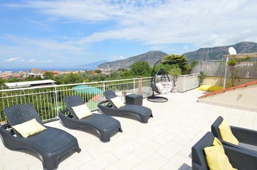 eine Terrasse mit Stühlen und Bergblick in der Unterkunft La Terrazza Family Holidays, Sorrento Coast in Sant'Agnello