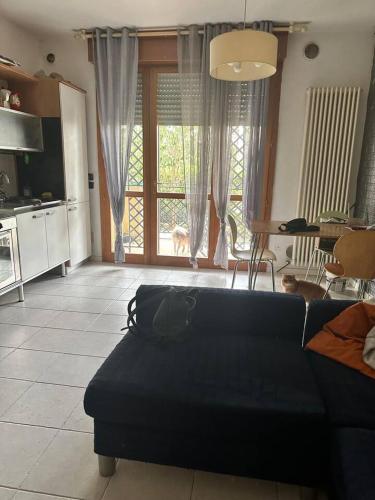 un salon avec un canapé noir et une cuisine dans l'établissement Marias House, à Rimini