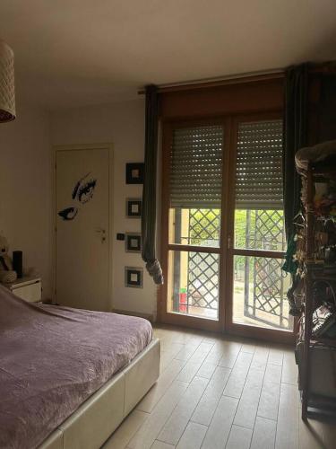 a bedroom with a bed and a large window at Marias House in Rimini