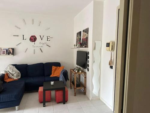 a living room with a blue couch and a clock on the wall at Marias House in Rimini