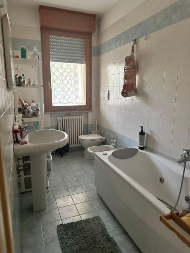 La salle de bains est pourvue d'une baignoire, d'un lavabo et de toilettes. dans l'établissement Marias House, à Rimini