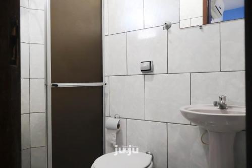 a bathroom with a toilet and a sink at Pousada Ju&Ju à 400 mts DA PRAIA in Pontal do Paraná