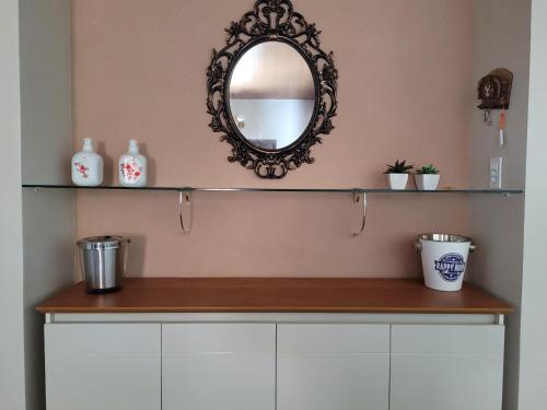 a mirror on the wall above a counter in a bathroom at Casa Praia Frances 350m orla Q4 novíssima e superdecorada in Marechal Deodoro