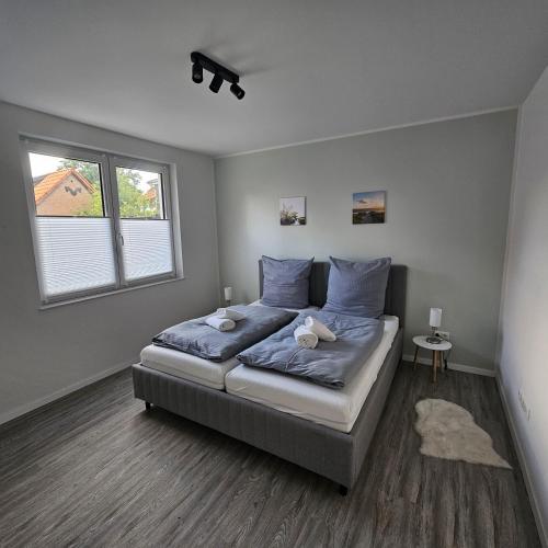 a bedroom with a bed with blue sheets and a window at Ferienwohnung - Melina - in Winsen