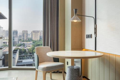 a table and chair in a room with a window at Element Guangzhou Baiyun in Guangzhou