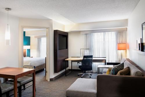 Residence Inn Cincinnati Airport في إيرلانغر: غرفة في الفندق مع أريكة وسرير ومكتب