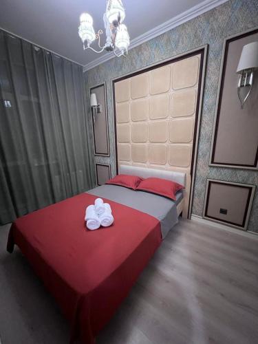 - une chambre avec un lit rouge et 2 serviettes dans l'établissement Набережная Астаны, à Astana