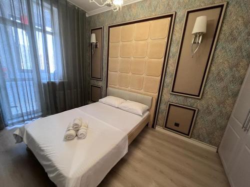 - une chambre avec un lit avec deux chaussures dans l'établissement Набережная Астаны, à Astana