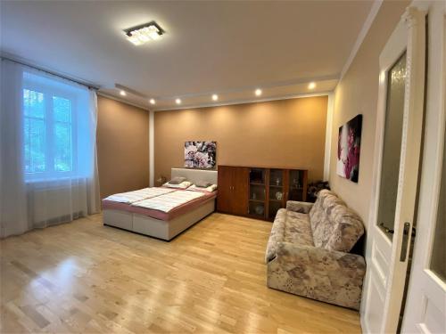 a bedroom with a bed and a couch in a room at Holičák in Olomouc